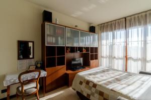 een slaapkamer met een bed en een bureau met een televisie bij Suite Carpiano in Melegnano