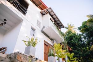 a white house with plants in front of it at Brown Birds Villa in Tangalle