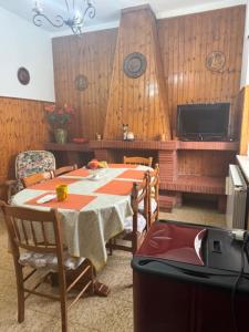 a dining room with a table and a television at Casa Vacanze Nonna Mena in Fontechiari