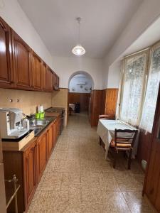 a kitchen with wooden cabinets and a table in it at Casa Vacanze Nonna Mena in Fontechiari +7 photos