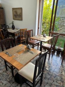 een eetkamer met houten tafels en stoelen en een raam bij Villa Starova in Berat