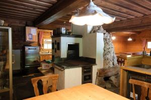 een keuken met een fornuis, een tafel en stoelen bij Landhotel Oberwengerhof in Spital am Pyhrn