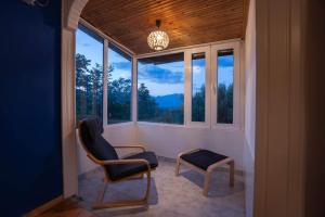 a porch with two chairs and a table and windows at Gurba's House in Aridaia