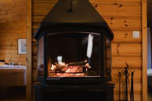 a fireplace with meat cooking in it in a room at Matilda Villas, quality villas by the sea in the beautiful village of Mathildedal in Matildedal