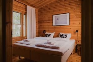 a bedroom with a bed in a wooden room at Matilda Villas, quality villas by the sea in the beautiful village of Mathildedal in Matildedal