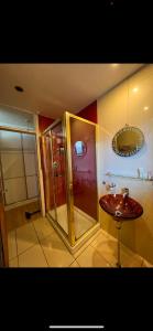 a bathroom with a shower and a sink and a mirror at Zen suite in Oadby