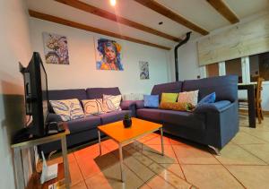 a living room with a purple couch and a table at Areatza Home Mountain in Santiago de la Espada