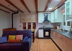 a living room with a blue couch in a kitchen at Areatza Home Mountain in Santiago de la Espada