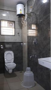 a bathroom with a toilet and a sink at Blossom Service Apartment in Mysore +18 photos