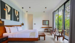 a bedroom with a bed and some windows at Namara Green Ella in Ella