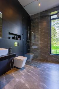 a bathroom with a toilet and a glass shower at Namara Green Ella in Ella +30 photos