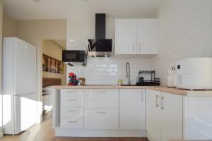 a white kitchen with white cabinets and appliances at San Ambrosio in Granada