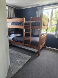 a bedroom with two bunk beds and a window at Livingstone Retreat in Hokitika