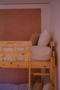 un letto a castello con lenzuola bianche e cuscini di Catamaran Surf House a Agadir nʼ Aït Sa