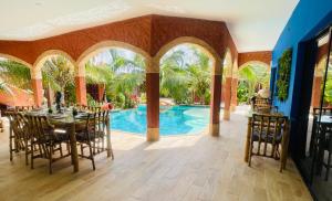 a dining room with a table and a swimming pool at Téranga paradis in Somone