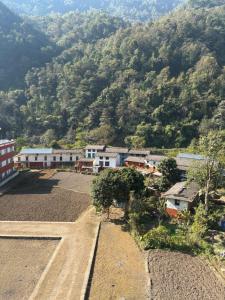 a village with a mountain in the background at Gauthali Inn in Netadurling