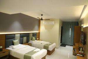 a hotel room with two beds and a television at Hotel N Grand in Miriālgūda +9 photos