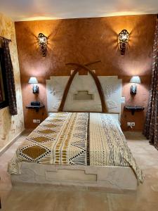 een groot bed in een kamer met 2 verlichting bij Téranga paradis in Somone +76 foto's