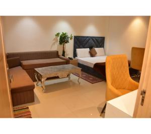 a room with a bed and a couch and a table at The Kuber Hotel in Bareilly