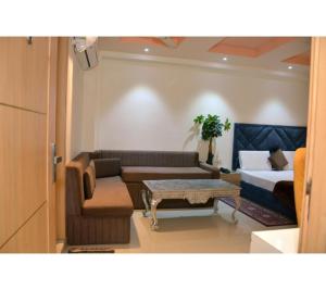 a living room with a couch and a bed at The Kuber Hotel in Bareilly