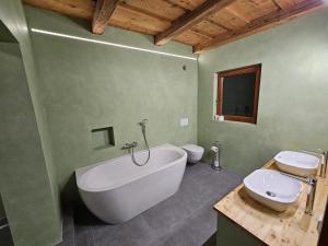 a bathroom with a large tub and two toilets at Bergbauer Offenburg in Pöls +8 photos
