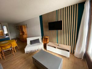 a living room with a table and a tv on a wall at Ax 3 domaines in Ax-les-Thermes