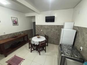 a kitchen with a table and a kitchen with a stove at Casas do Matteo - 2ª Praia in Morro de São Paulo