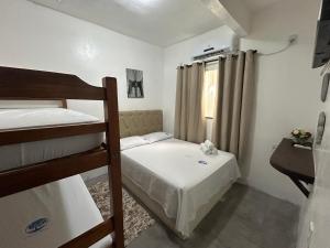 a bedroom with two bunk beds and a window at Casas do Matteo - 2ª Praia in Morro de São Paulo
