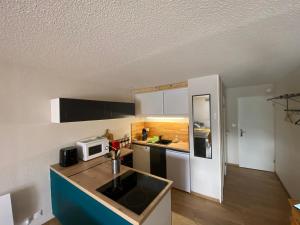 a kitchen with a white refrigerator and a microwave at Ax 3 domaines in Ax-les-Thermes