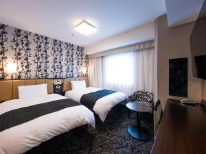a hotel room with two beds and a window at APA Hotel Nagoya Ekimae in Nagoya +89 photos