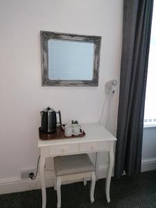 a white table with a tea pot and a mirror at The Kirkview in Blackpool +31 photos