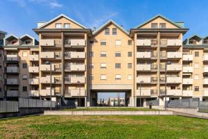 een groot appartementengebouw met een grasveld ervoor bij Suite Carpiano in Melegnano