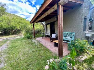 a covered patio with a bench and a table at Iris,Tiny house en Las Calles, Traslasierra in Las Calles