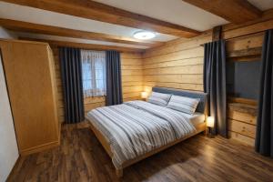 a bedroom with a bed with wooden walls and a television at Bergbauer Offenburg in Pöls