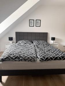 a bedroom with a bed with two pictures on the wall at Gemütliche Wohnung über den Dächern von Gevelsberg in Gevelsberg