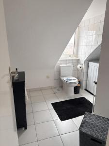 a white bathroom with a toilet and a sink at Gemütliche Wohnung über den Dächern von Gevelsberg in Gevelsberg +18 photos