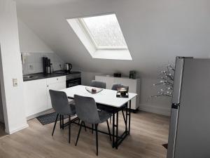 a kitchen with a table with chairs and a skylight at Gemütliche Wohnung über den Dächern von Gevelsberg in Gevelsberg