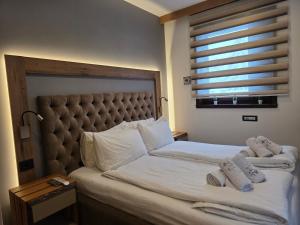 een slaapkamer met een groot bed met twee handdoeken erop bij Vila Pahulja A3 in Kopaonik