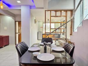 una sala da pranzo con tavolo e sedie di ll EMPYREAN STAY ll SUPREME VILLA ll 3BHK II PVT POOL II MINI BAR AREA II AC a Lonavala