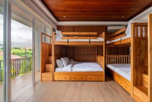 two bunk beds in a room with a balcony at Aresty 3 Bedroom Villa Canggu in Canggu +107 photos