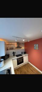 una cucina con pareti rosse e piano cottura forno superiore di Alpine Apartments - 1 a Blairgowrie