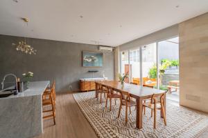 a kitchen and dining room with a wooden table and chairs at Aresty 3 Bedroom Villa Canggu in Canggu