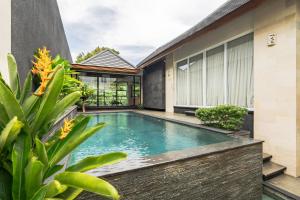 an infinity pool in the backyard of a house at Aresty 3 Bedroom Villa Canggu in Canggu