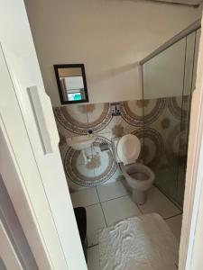 a bathroom with a toilet and a glass shower at Prédio AZUL in Itacaré