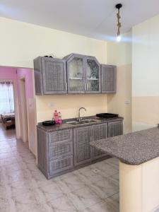 an empty kitchen with gray cabinets and a sink at Seaview horizon apartment in Sowayma