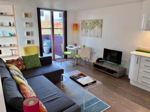 a living room with a couch and a table at Regatta - A lakeview apartment in Thorpeness - Aldeburgh Coastal Cottages in Thorpeness