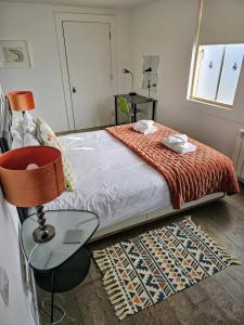 a bedroom with a bed and a table with a lamp at Regatta - A lakeview apartment in Thorpeness - Aldeburgh Coastal Cottages in Thorpeness