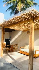 a wooden pergola with a bed and a table at Villa Canaria - Luxury New Villa Private Pool in Gili Trawangan