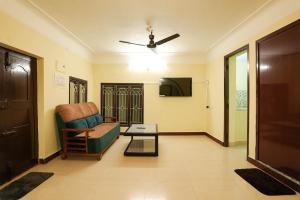 a living room with a chair and a tv at Ashu Homestay Nest 1 in Pondicherry +1 photo