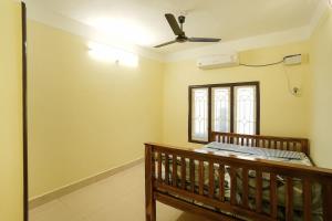 a room with a ceiling fan and a bench at Ashu Homestay Nest 1 in Pondicherry